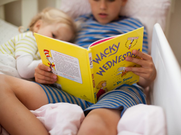 Boy reading to younger sister